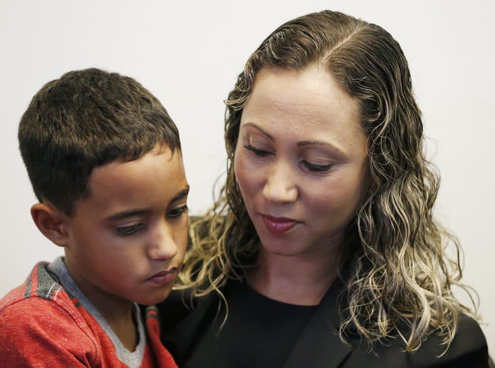 A Brazilian mother, who asked to be identified only as W.R., holds her 9 year-old son A.R. during a news conference at the Brazilian Worker Center in Boston on July 16. The mother spoke to reporters after she was reunited with her son at Boston's Logan Airport. (Michael Dwyer/AP)