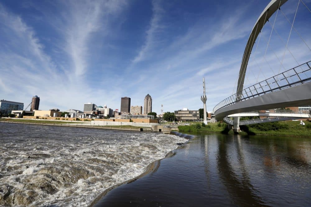 In this Wednesday, June 13, 2018, photo, the Des Moines River water flows over the Center Street Dam, in downtown Des Moines, Iowa. US cities are building whitewater courses and encouraging greater use of urban waterways, but the efforts come as they struggle with pollution in their rivers. In Des Moines, officials support a $117 million plan to attract paddlers to often polluted rivers in the citys downtown and suburbs. (AP Photo/Charlie Neibergall)