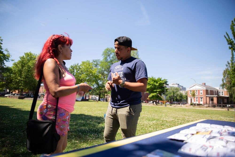 Community Renewal Team's Jovany Rolon speaks to Carmen Cruz about PrEP medication for HIV prevention in Hartford's Barnard Park. (Ryan Caron King/NENC)