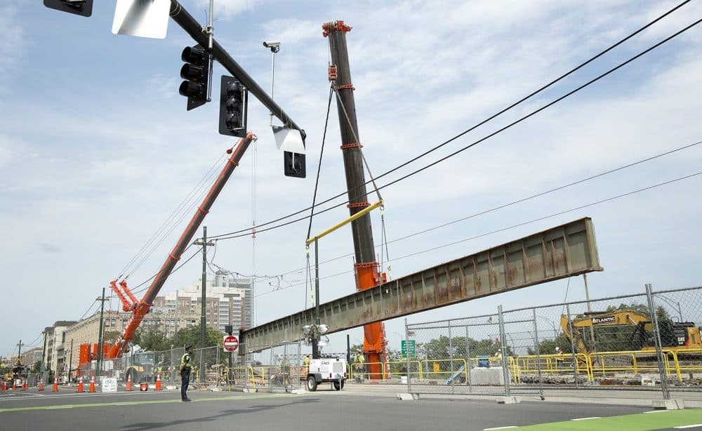 A crane lifts one of the old beams from Commonwealth Avenue Bridge, as part of the bridge replacement project, on June 30. (Robin Lubbock/WBUR)