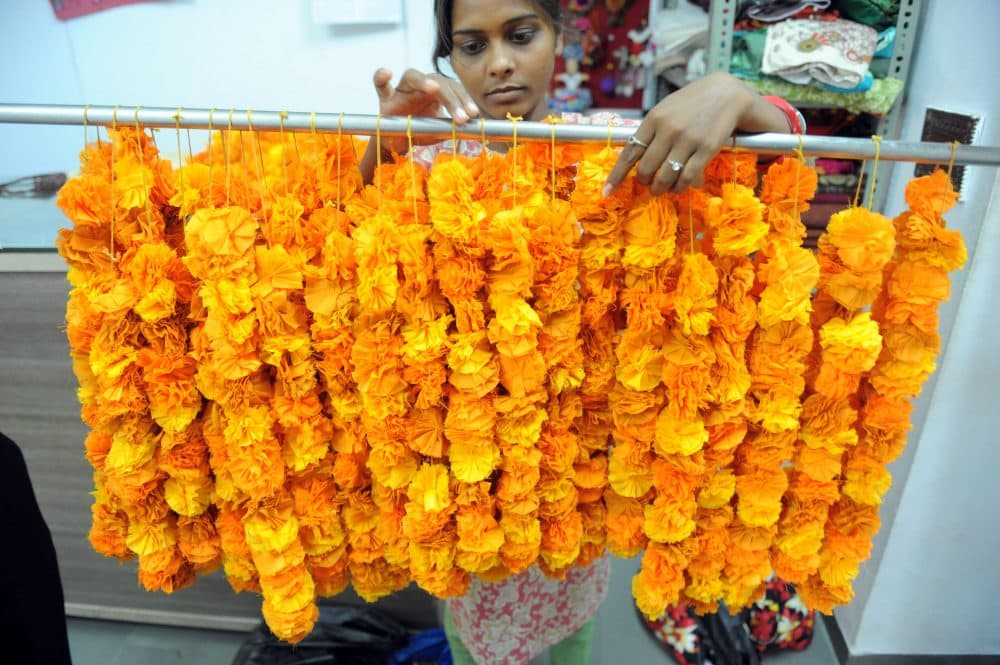 An Indian employee arranges floral garlands made from fabric for a wedding decoration. (Sam Panthaky/AFP/Getty Images)