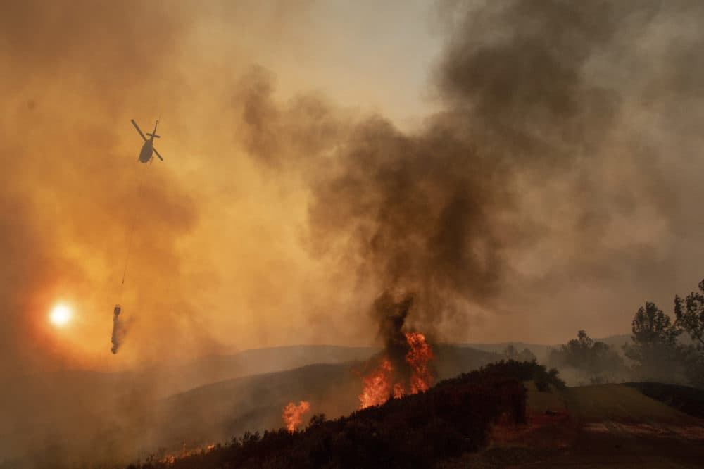 In this Sunday, Aug. 5, 2018, file photo, a helicopter drops water on a burning hillside during the Ranch Fire in Clearlake Oaks, Calif. Authorities say a rapidly expanding Northern California wildfire burning over an area the size of Los Angeles has become the state's largest blaze in recorded history. It's the second year in a row that California has recorded the state's largest wildfire. (Josh Edelson, File/AP)