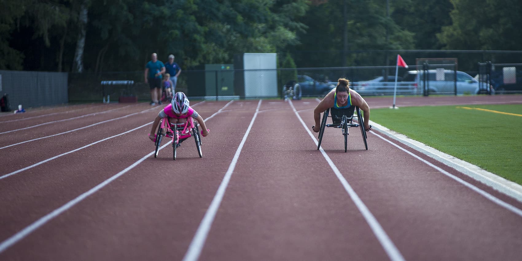 Maddie Wilson, left, and Tatyana McFadden work out together at Wellesley High School, preparing for the upcoming Falmouth Road Race. (Jesse Costa/WBUR)