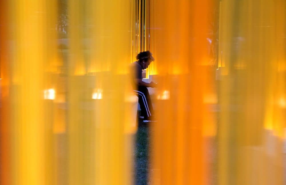 A visitor sits in one of the inner circles of Teresita Fernández's &quot;Autumn (…Nothing Personal).&quot; (Robin Lubbock/WBUR)