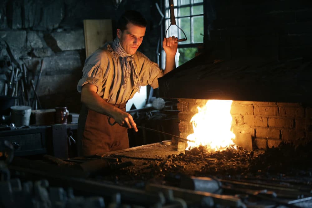 Derek Heidemann reenacts an 1830s blacksmith at Old Sturbridge Village. (Steven Senne/AP)