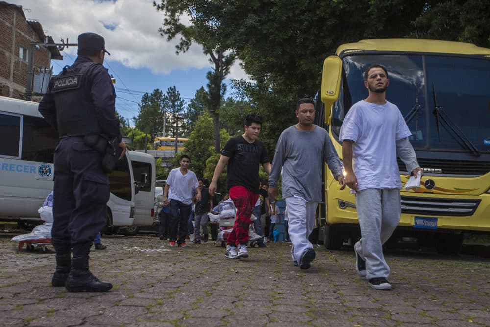 Dos autobuses de aproximadamente 50 deportados de los Estados Unidos ingresan al Centro de Migración en San Salvador para volver a ingresar a El Salvador. (Jesse Costa/WBUR)