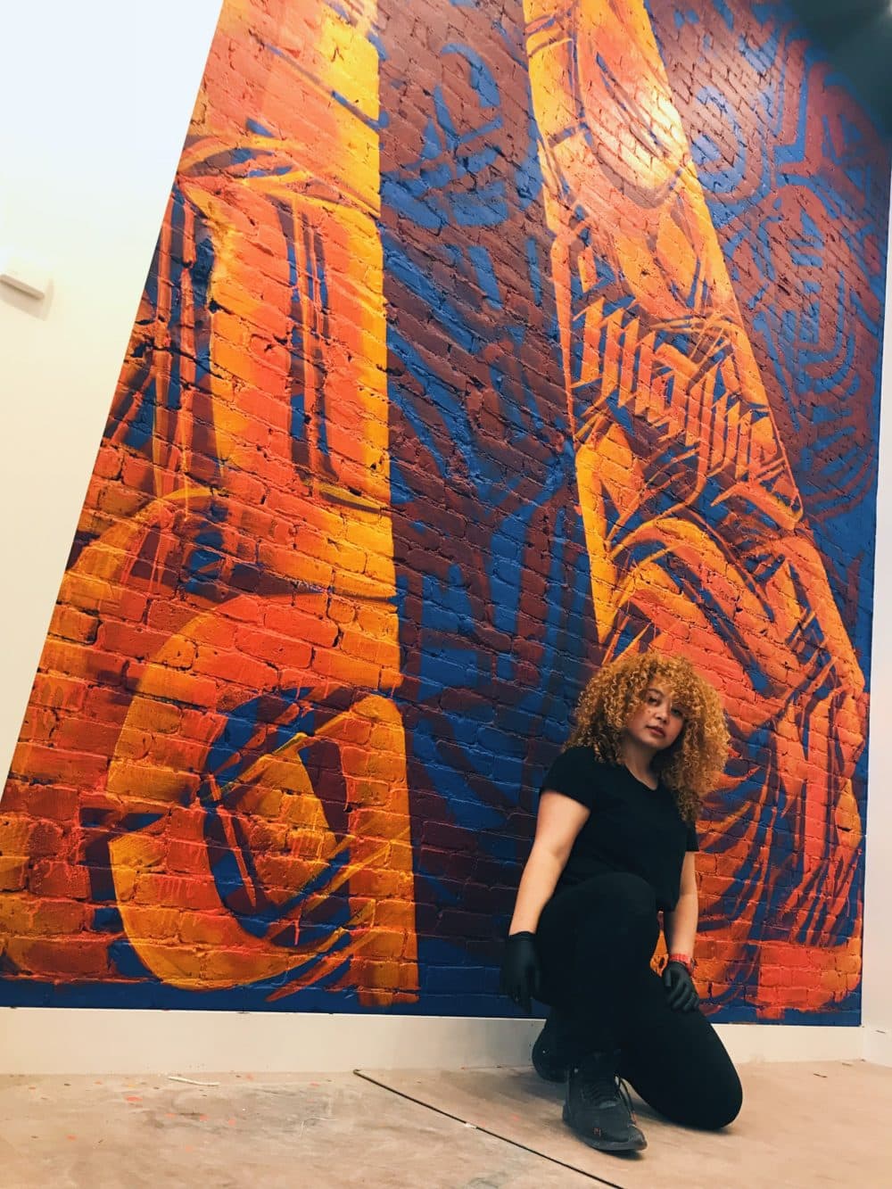 Artist Sneha Shrestha in front of one of her murals. (Courtesy of the artist)