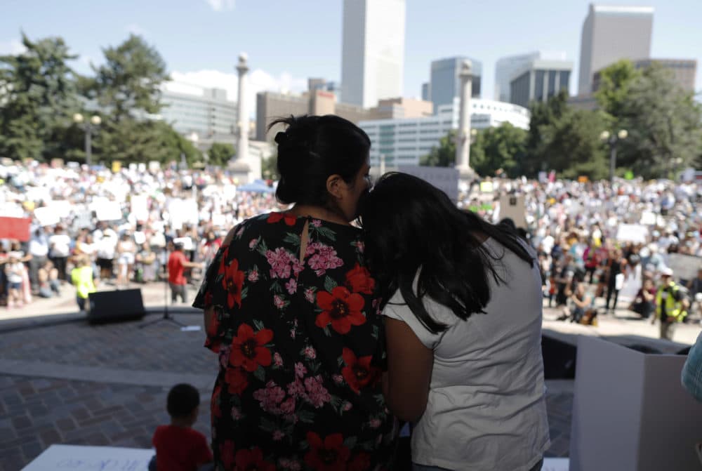Brenda Villa, left, comforts her 11-year-old daughter, Kathryn, after speaking during an immigration rally and protest in Civic Center Park Saturday, June 30, 2018, in downtown Denver. (David Zalubowski/AP)