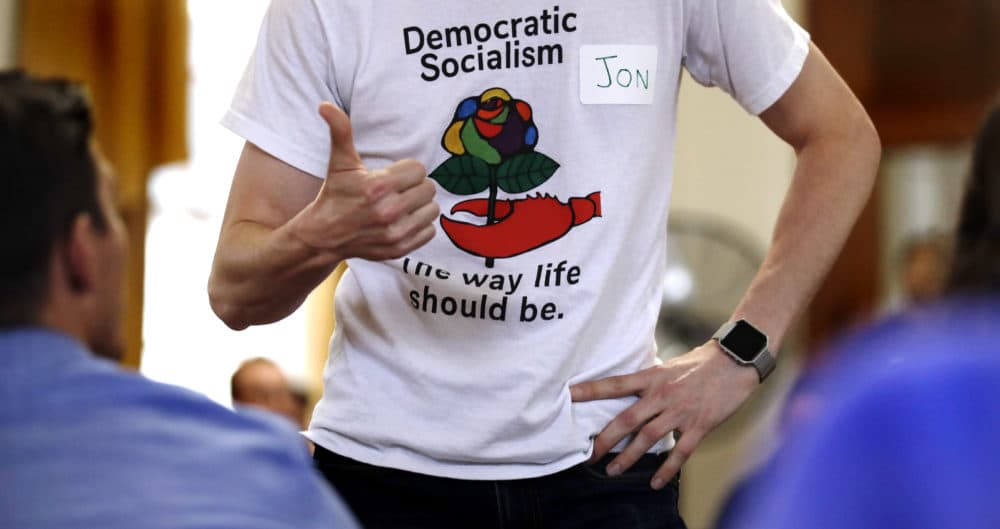 Jon Torsch, center, wears a t-shirt promoting democratic socialism during a gathering of the Southern Maine Democratic Socialists of America at City Hall in Portland, Maine, Monday, July 16, 2018. On the ground in dozens of states, there is new evidence that democratic socialism is taking hold as a significant force in Democratic politics. (Charles Krupa/AP)