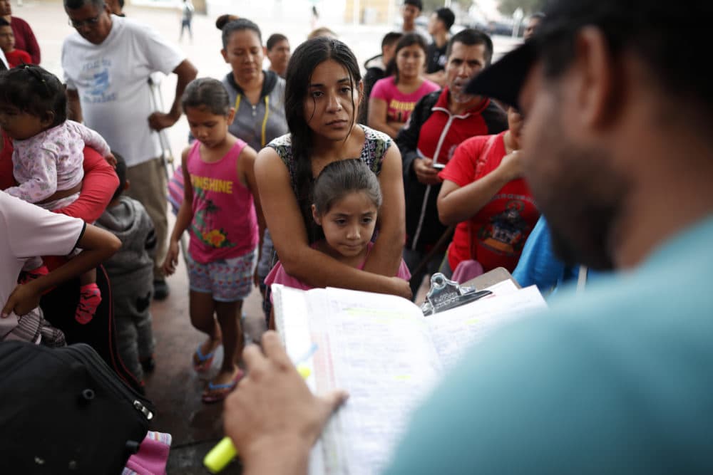 A woman from the Mexican state of Michoacan who did not give her name stands with her daughter as names are read off a list of people who will cross into the United States to begin the process of applying for asylum Thursday, July 26, 2018. (Gregory Bull/AP)