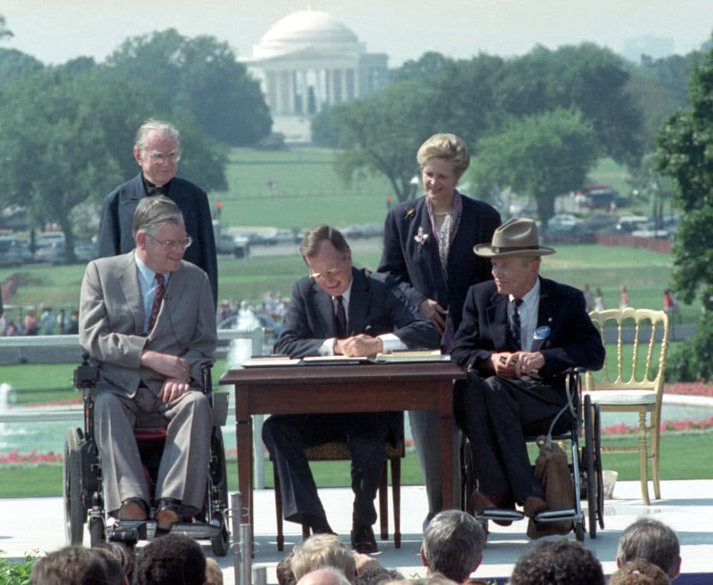 In this July 26, 1990 file photo, President George H. W. Bush signs the Americans with Disabilities Act during a ceremony on the South Lawn of the White House. Joining the president are, from left, Evan Kemp, chairman of the Equal Opportunity Employment Commission; Rev. Harold Wilke; Sandra Parrino, chairman of the National Council on Disability, and Justin Dart, chairman of The President's Council on Disabilities. The Americans with Disabilities Act, which was signed into law 25 years ago, on July 26, 1990. (Barry Thumma/AP)