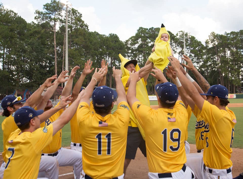 Players salute a banana-clad baby before a game. (Courtesy Jesse Cole)