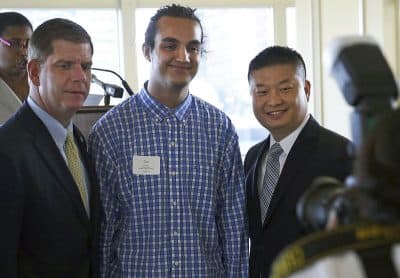 In this May 31, 2016 photo, Joel Ortiz, center, poses for a photo with Mayor Marty Walsh, left, and public schools Superintendent Tommy Chang, right, during a luncheon for public schools valedictorians in Boston. Ortiz, who studies information technology at University of Massachusetts, Boston, was arrested on July 12, 2018, at Los Angeles International Airport, on suspicion of using his tech skills to hack victims’ personal cell phones and steal millions of dollars in digital currency. (Jessica Rinaldi/The Boston Globe via AP)
