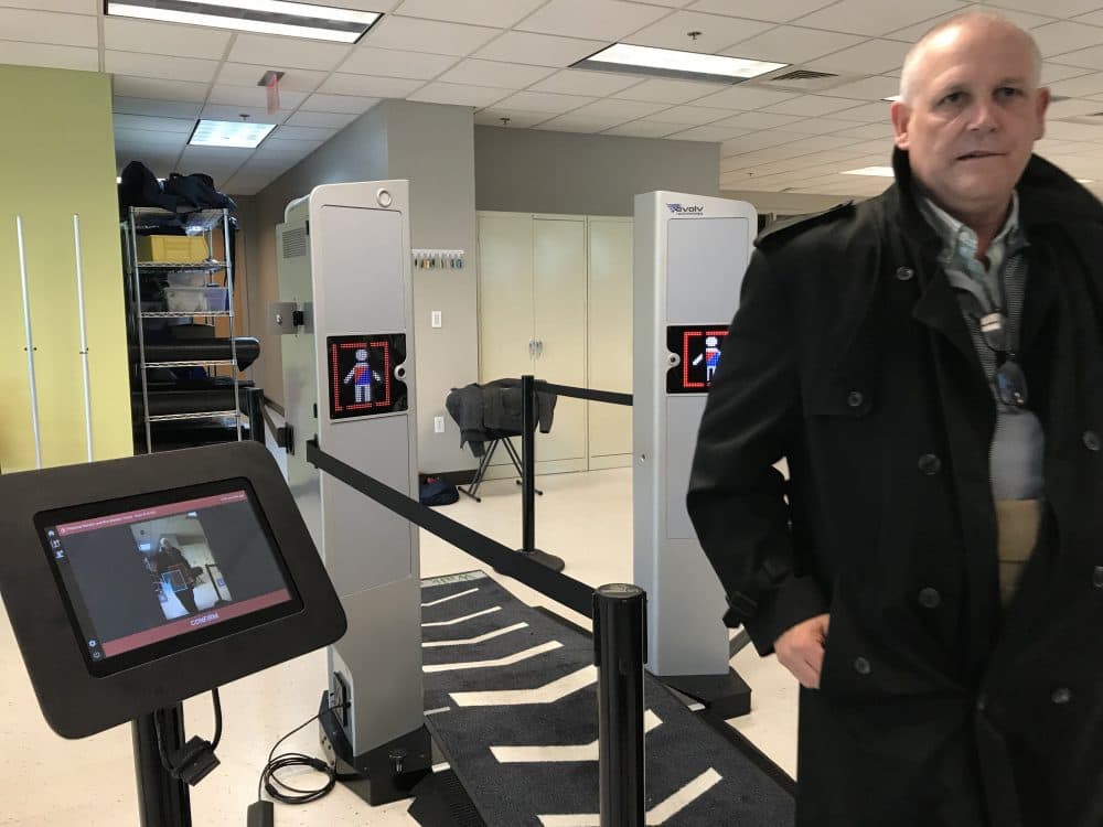 Mike Martin of Evolv Technology demonstrates how the company's threat detector can sense metallic and nonmetallic weapons. Martin is concealing a pistol and a mock explosive vest under his jacket. (Callum Borchers/WBUR)