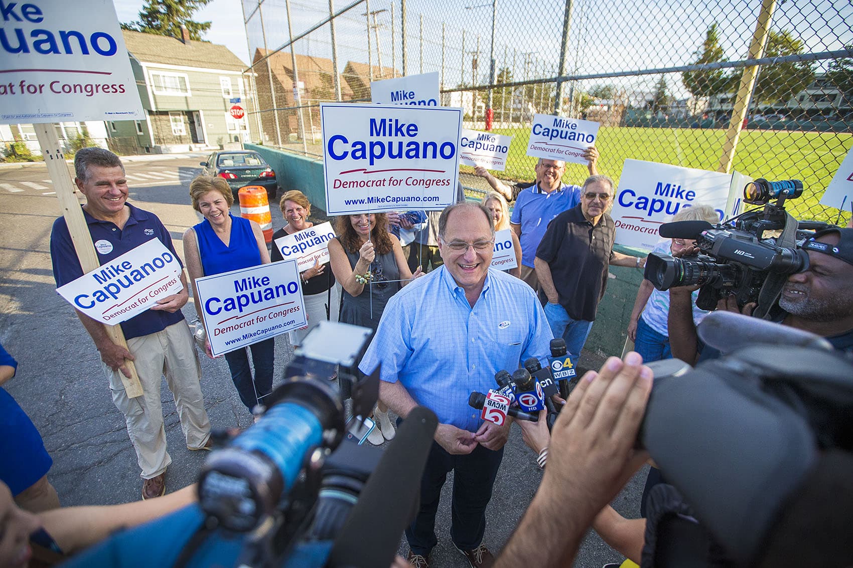 With supporters behind him, U.S. Rep. Michael Capuano speaks with the media outside of Trum Field in Somerville in the early morning of primary voting day. (Jesse Costa/WBUR)