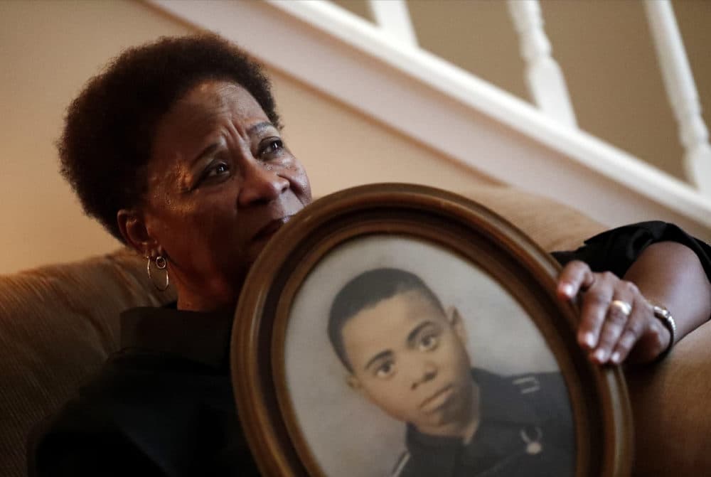 In this Aug. 9, 2018 photo, Eberlene King poses with a photograph of her brother William Roy Prather when he was about 15 years old at her home in Doraville, Ga. Prather was shot in the face on Halloween night 1959 in Corinth, Miss., and died the next day. (John Bazemore/AP)