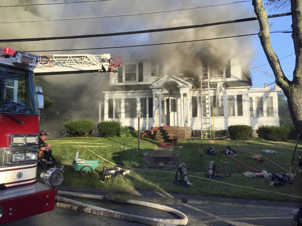 Firefighters battle a house fire on Herrick Road in North Andover, Mass., one of multiple emergency crews responding to a series of gas explosions and fires triggered by a problem with a gas line that feeds homes in several communities north of Boston. (Mary Schwalm/AP)