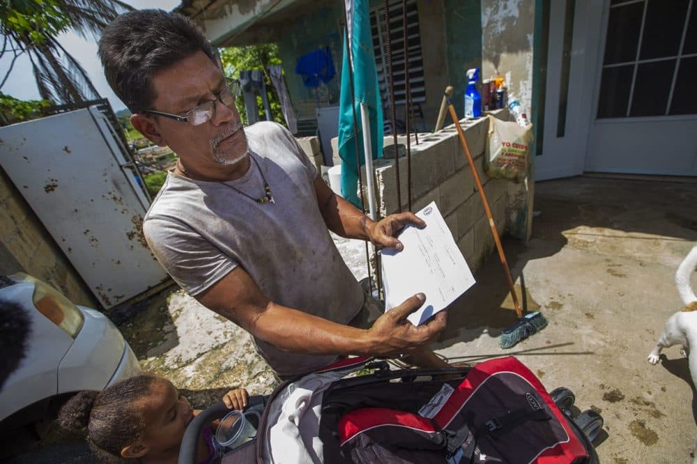It took six months for power to be restored in the Toa Baja area after Hurricane Maria. Here, Israel Figueroa shows an electric bill from Autoridad de Energia Electrica de Puerto Rico, which includes service charges for electricity in February and March 2018, even though power was not returned until April. (Jesse Costa/WBUR)