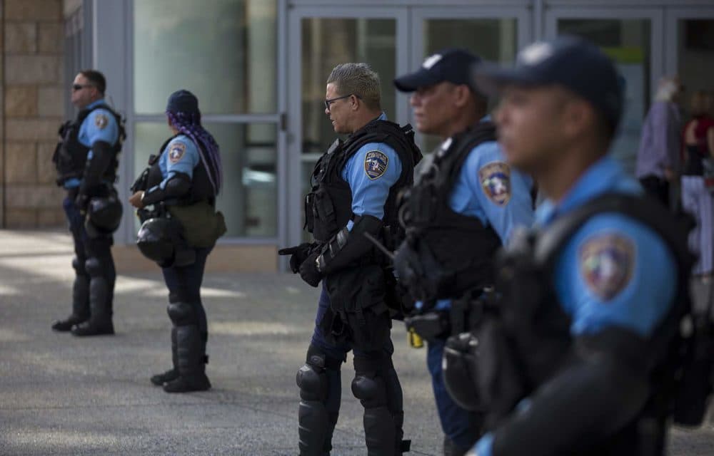 Police stand outside the convention center during a conference held by the fiscal control board for Puerto Rico to manage a planned protest that never materialized. Residents are unhappy with austerity measures recommended by the board and the local government. (Jesse Costa/WBUR)