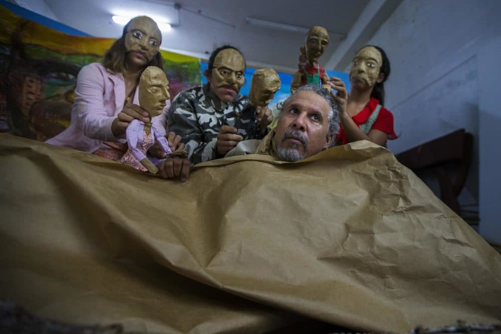 Pedro Adorno, front, and a portion of his Agua, Sol, y Sereno theater company rehearse a portion of their show,&quot;Corazón de Papel: A Hurricane Story,&quot; a portrayal of the post-Maria disaster. (Jesse Costa/WBUR)