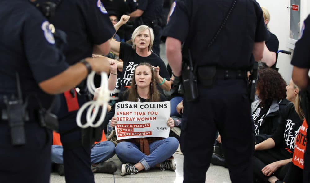 Protesters sit and chant against Judge Brett Kavanaugh as Capitol Hill Police officers make arrests outside the office of Sen. Susan Collins, R-Maine, on Capitol Hill. (Alex Brandon/AP)