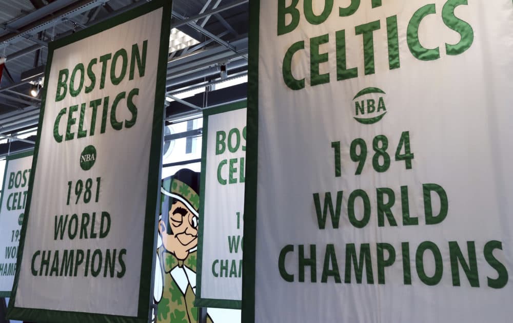 Lucky the Leprechaun, the Boston Celtics team logo, peers out from in between Celtics championship banners hanging in their new basketball team practice facility. (Elise Amendola/AP)