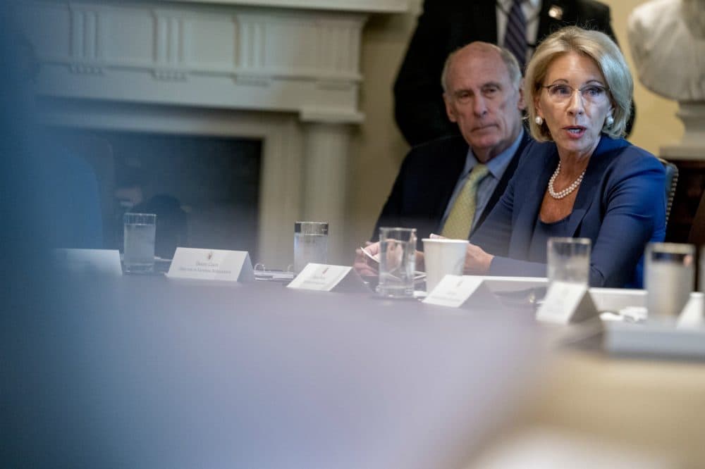 Education Secretary Betsy DeVos, right, accompanied by Director of National Intelligence Dan Coats, left, speaks during a cabinet meeting in the Cabinet Room of the White House on Aug. 16. (Andrew Harnik/AP)