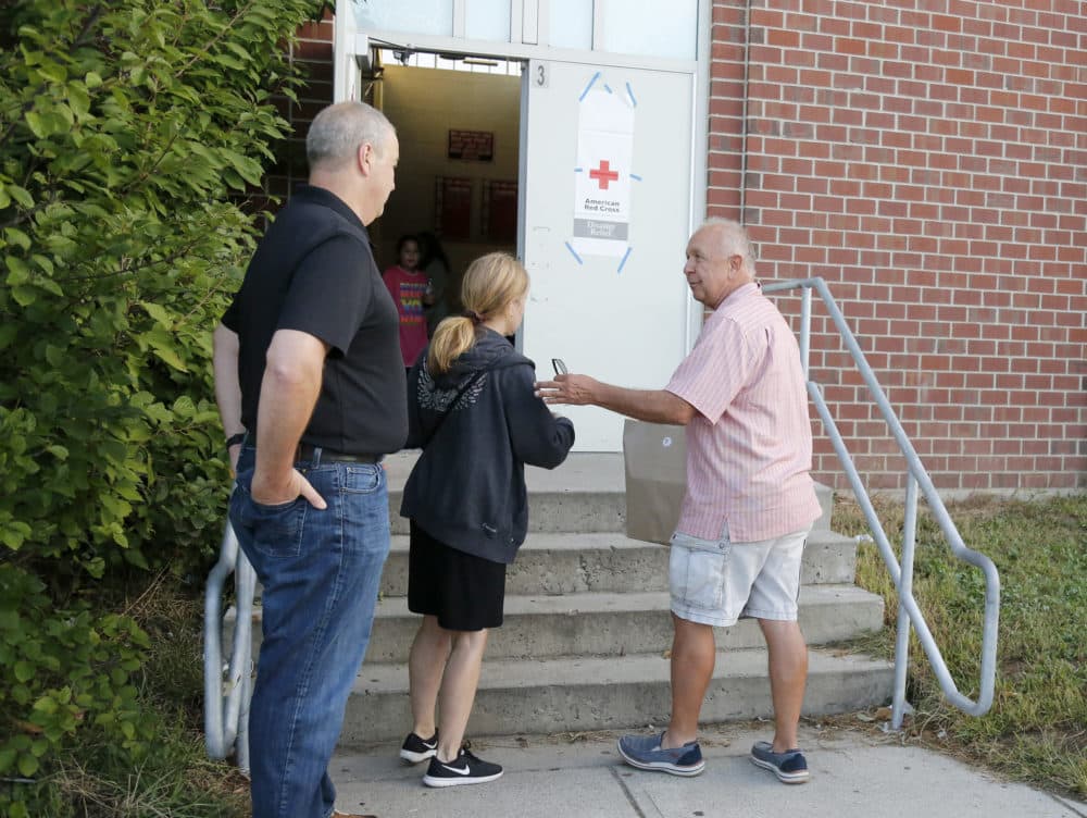 Michael Smolak, of Smolak Farms in North Andover, delivers a bag of baked goods to the emergency shelter set up at North Andover High School on Friday. (Mary Schwalm/AP)