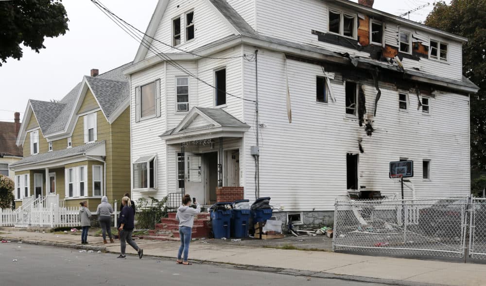 Lawrence residents stop to take photos of a house on Bowdoin Street in Lawrence Friday. (Mary Schwalm/AP)