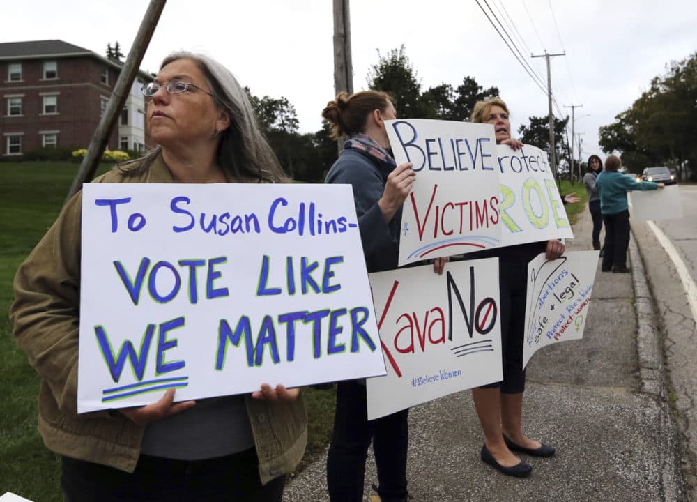 Demonstrators hold signs outside Saint Anselm College, Friday, Sept. 21, 2018, in Manchester, N.H., where U.S. Sen. Susan Collins, R-Maine, considered one of the few possible Republican &quot;no&quot; votes on Supreme Court nominee Brett Kavanaugh, is scheduled to speak. (Elise Amendola/AP)