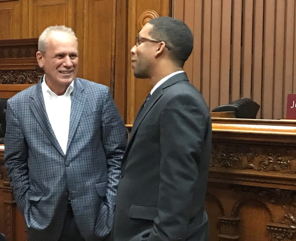 Larry Lucchino, left, co-owner of the Red Sox's top farm team, grinned after Sean Rose and the Worcester City Council approved a stadium financing plan for the baseball club. (Callum Borchers/WBUR)