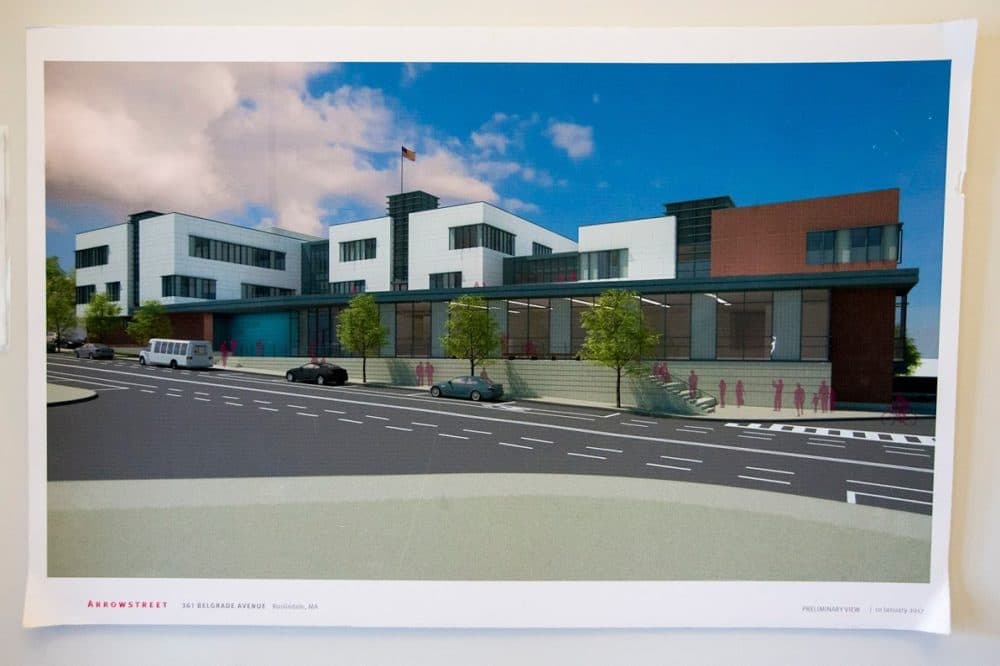 A rendering of the proposed new high school at 361 Belgrade Avenue hanging in the doorway of the Maywood campus. (Jesse Costa/WBUR)