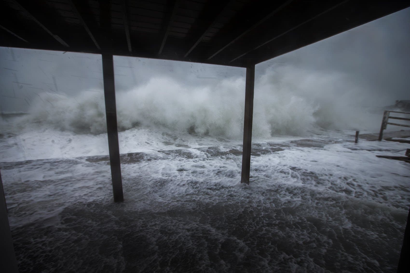 Waves crash along the seawall on Oceanside Road in Scituate. (Jesse Costa/WBUR)