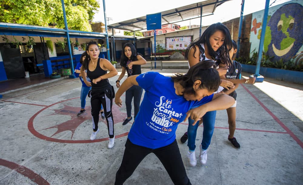 Volunteers for Glasswing International lead members of the Glee club in a dance routine at a school in Las Palmas, San Salvador, El Salvador. (Jesse Costa/WBUR)