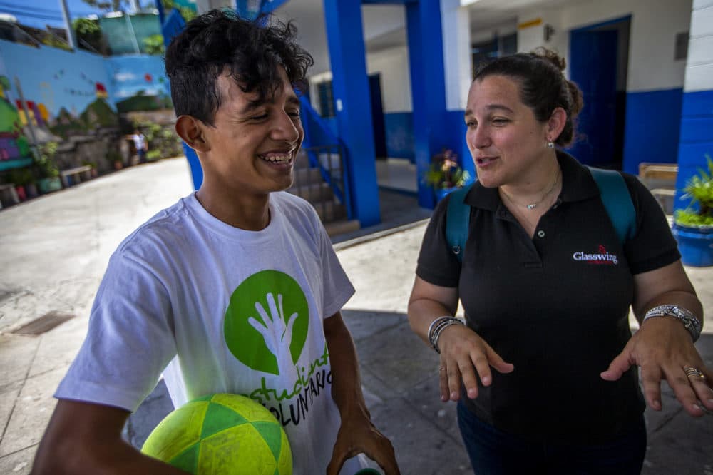 Celina de Sola, vice president if programs at Glasswing International, chats with one of the students at Centro Escolar Republica De Canada in the community of Las Palmas in San Salvador. (Jesse Costa/WBUR)