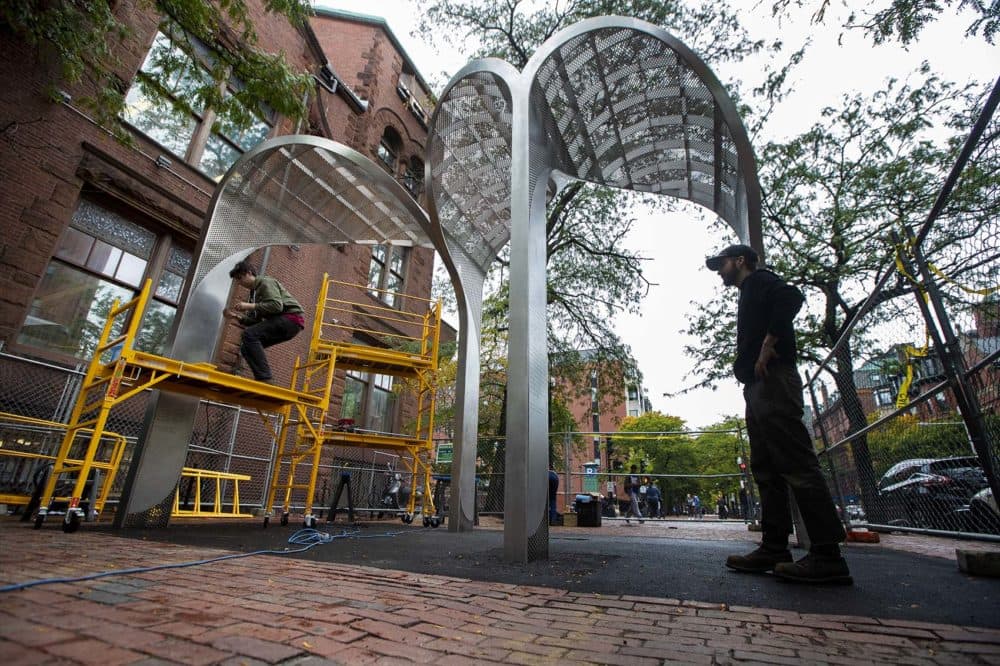 Workers from Whetstone Workshop place the finishing touches on to the Kip Tiernan Memorial on Dartmouth Street in Copley Square. (Jesse Costa/WBUR)