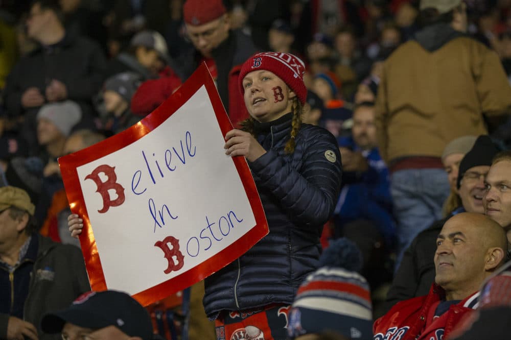 A Red Sox fan holds up a sign that read “Believe in Boston” during game one of the 2018 World Series . (Jesse Costa/WBUR)
