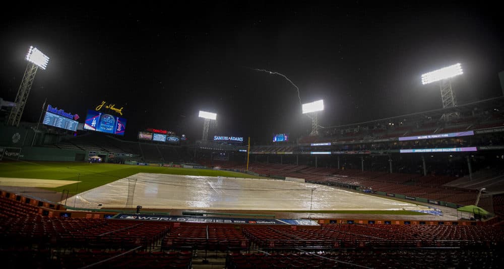 After Red Sox personel evacuate all open areas of the park, rain falls and lightning flashes over Fenway Park prior to the start of game one of the World Series. (Jesse Costa/WBUR)