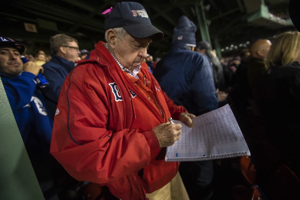 Longtime Red Sox fan Jerry Wise records a Chris Sale strikeout in his scorebook. (Jesse Costa/WBUR)