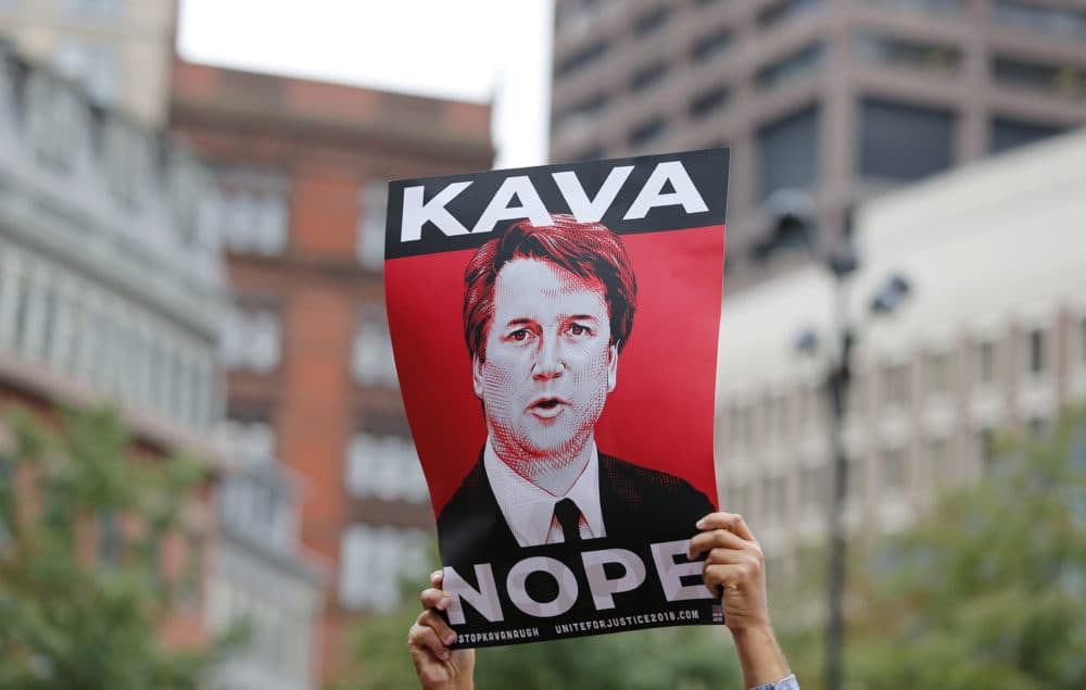 A protester holds a sign in opposition to Judge Brett Kavanaugh at a rally at City Hall ahead of an appearance by Sen. Jeff Flake, R- Ariz. at the Forbes 30 Under 30 Summit, Monday, Oct. 1, 2018, in Boston. (Mary Schwalm/AP)