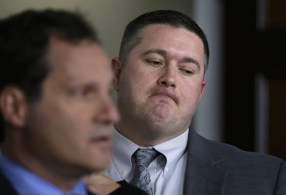 Boston cop Kurt Stokinger, right, stands near Jonathan Lowy, vice president of litigation at the Brady Center To Prevent Gun Violence, as Lowy speaks to reporters Thursday in Boston. The officer is suing an online marketplace where the gun used to shoot him was sold. (Steven Senne/AP)