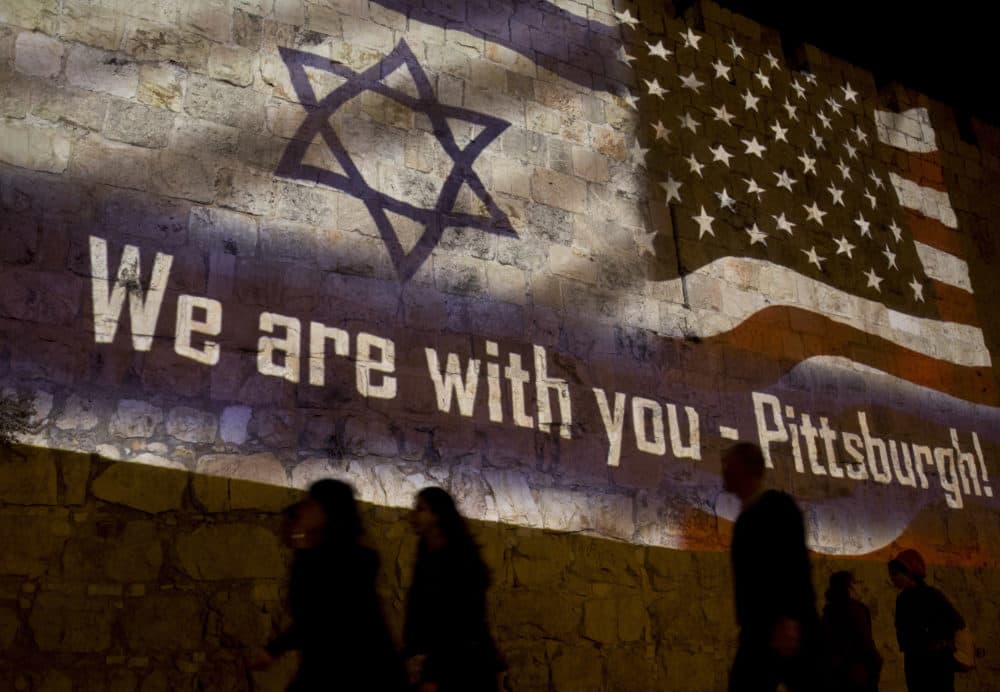 People walk past a projection on the Old City wall in Jerusalem, Sunday, Oct. 28, 2018 in a commemoration of the victims of a deadly shooting at a Pittsburgh synagogue. (Dusan Vranic/AP)