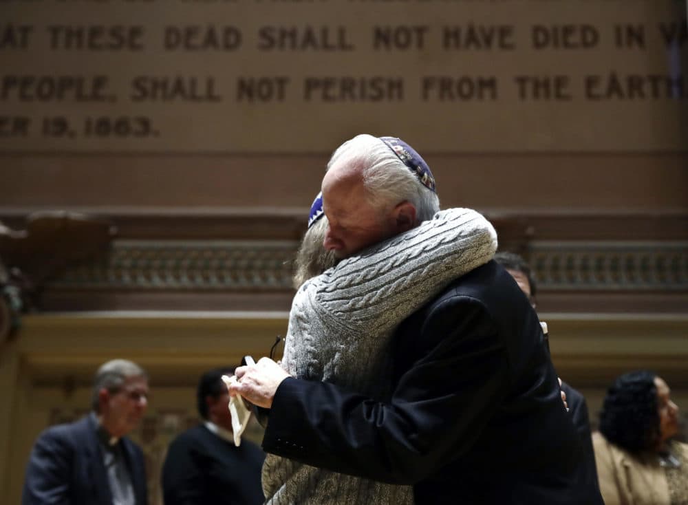 Rabbi Jeffrey Myers of Tree of Life/Or L'Simcha Congregation hugs Rabbi Cheryl Klein of Dor Hadash Congregation on the stage in Soldiers and Sailors Memorial Hall and Museum during a community gathering held in the aftermath of a deadly shooting at the Tree of Life Synagogue in Pittsburgh, Sunday, Oct. 28, 2018. (Matt Rourke/AP)