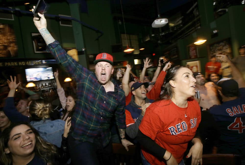 Boston Red Sox fans celebrate while watching a televised Game 5 World Series baseball game in a bar, in Boston. (Steven Senne/AP)