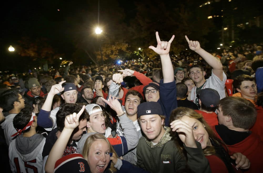 Boston Red Sox fans celebrate the team's victory in the World Series on the Boston Common, in Boston, early Monday, Oct. 29, 2018, after Red Sox beat the Los Angeles Dodgers 5-1, in Los Angeles on Sunday to win the series 4 games to 1. (Steven Senne/AP)