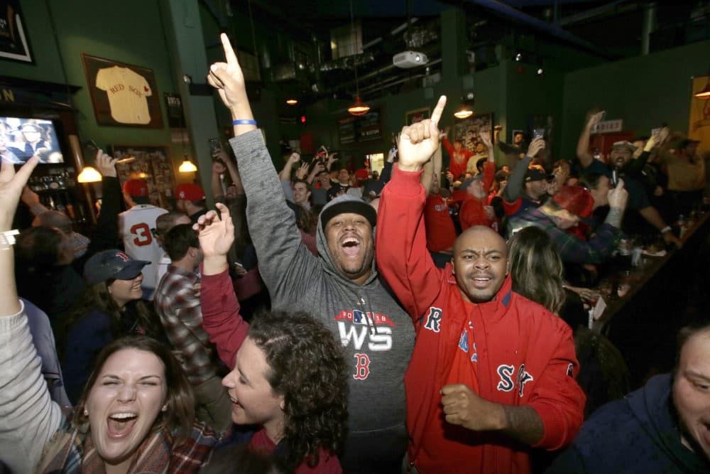 Boston Red Sox fans celebrate while watching a televised World Series baseball game in a bar, in Boston. (Steven Senne/AP)