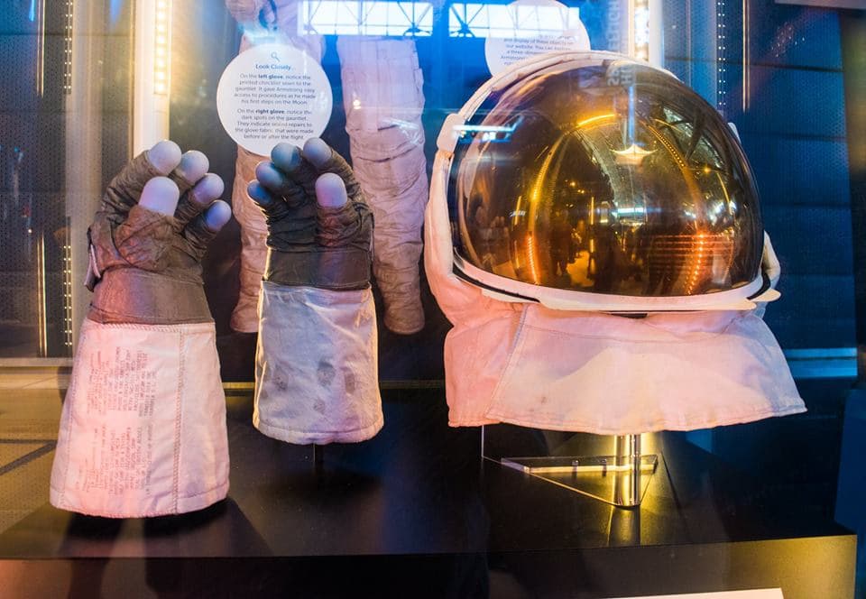 Armstrong's gloves and visor from the Apollo 11 lunar EVA. You can see lunar dust on the wrist, along with his checklist of what to do once he got out of the Lunar Module. (Brian Hardzinski/On Point)