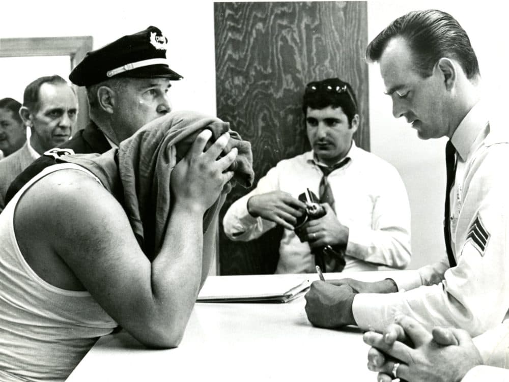 Chief Shea of the Natick police books Bobby Guarante on charges of robbing the First National Bank of Natick in September 1968. (Courtesy William Ryerson/Boston Globe)