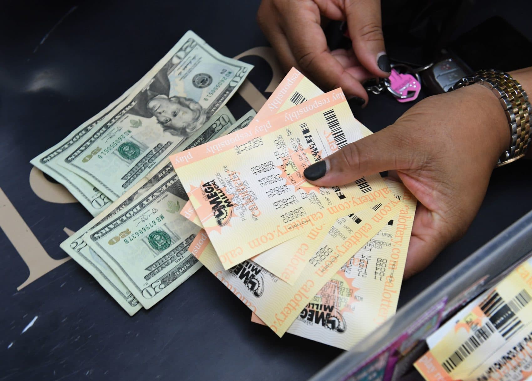 A woman shows her Mega Millions tickets hours before the draw of the $1 billion jackpot, at the Bluebird Liquor store in Torrance, Calif., Oct. 19, 2018. (Mark Ralston/AFP/Getty Images)