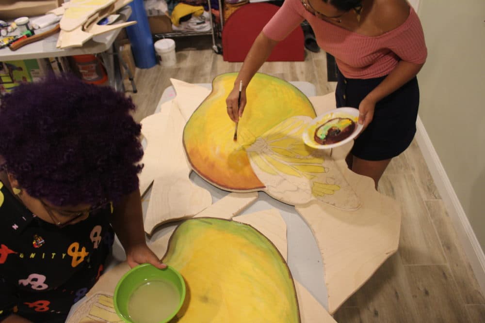 Artists Chanel Thervil, left, and Iris Lapaix prepare for &quot;Mariposas and Mangos.&quot; (Arielle Gray for WBUR)